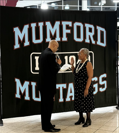 Reverend James Dodson swears in new Board of Education Member Ida Short at Mumford High School on December 4, 2024